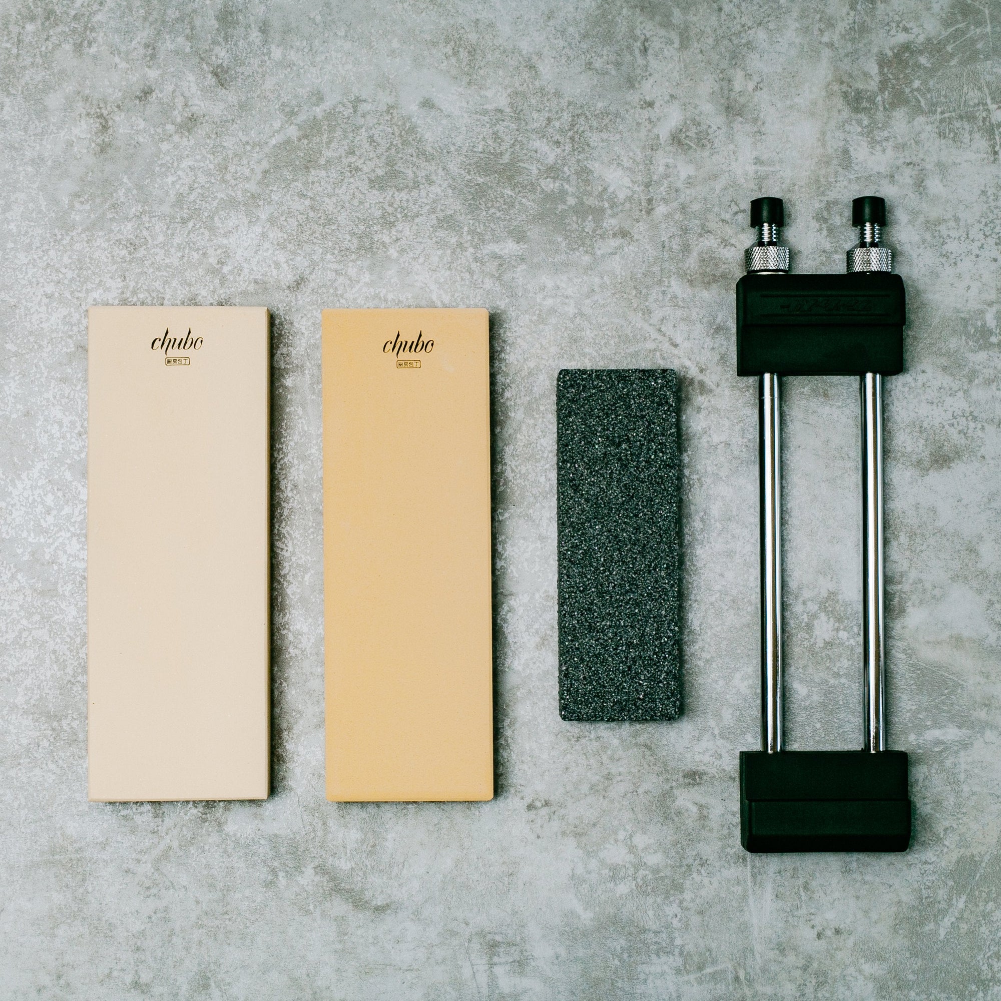 two sharpening stones, a stone fixer and stone base