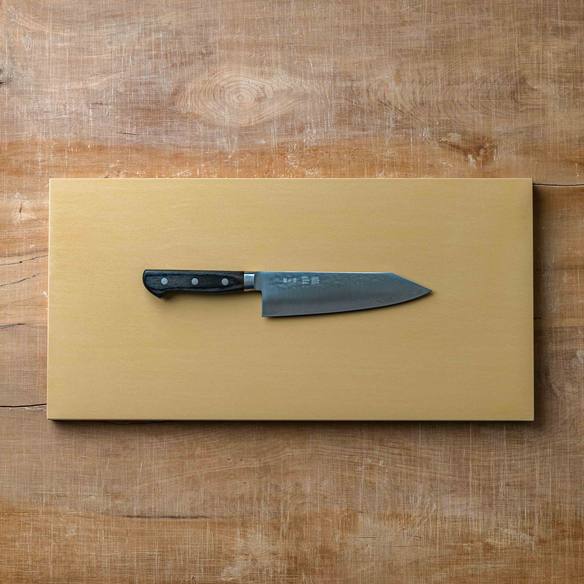a bunka knife on a hi soft cutting board