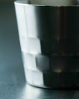 Shiny metallic cup on a dark surface