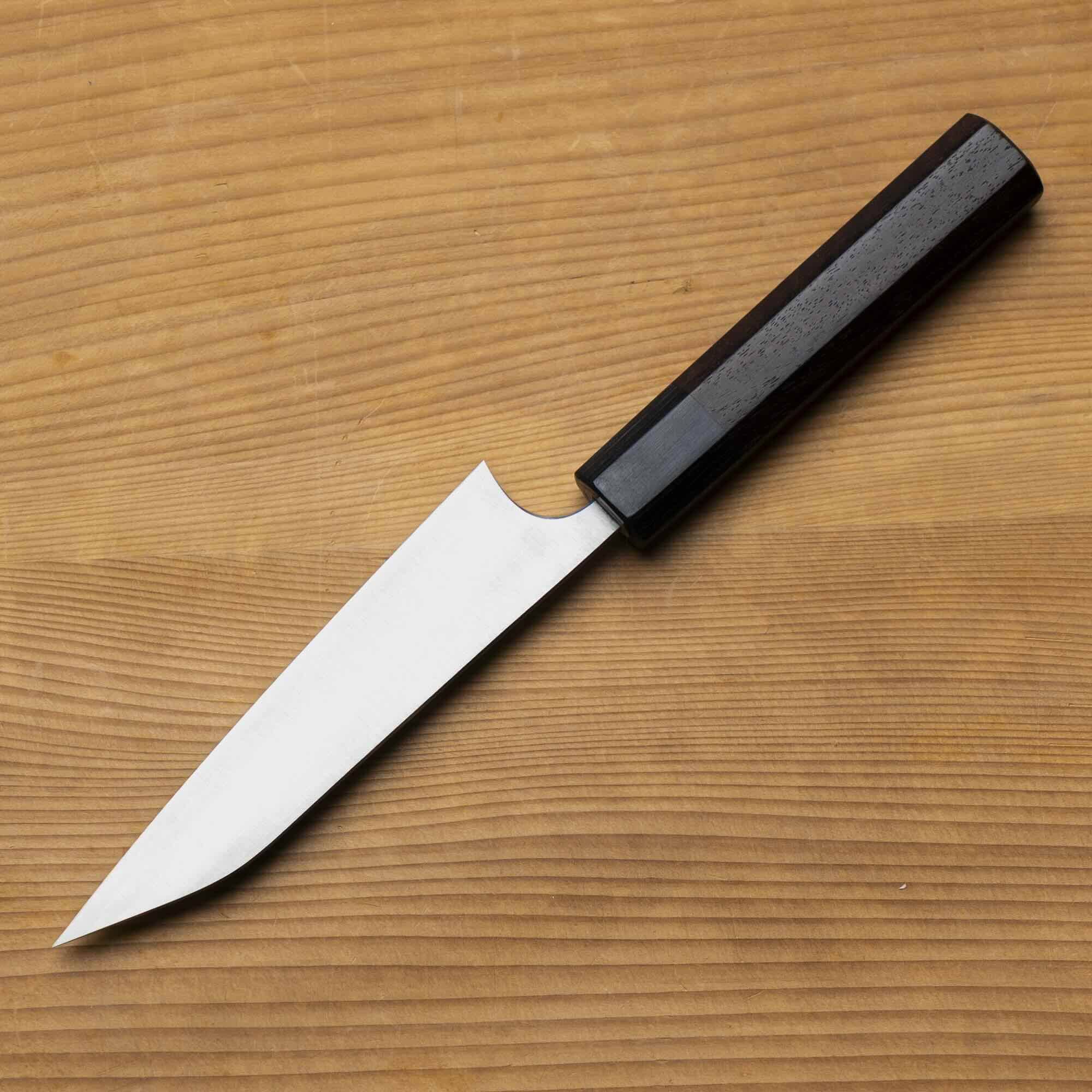 Knife with a black handle on a wooden surface