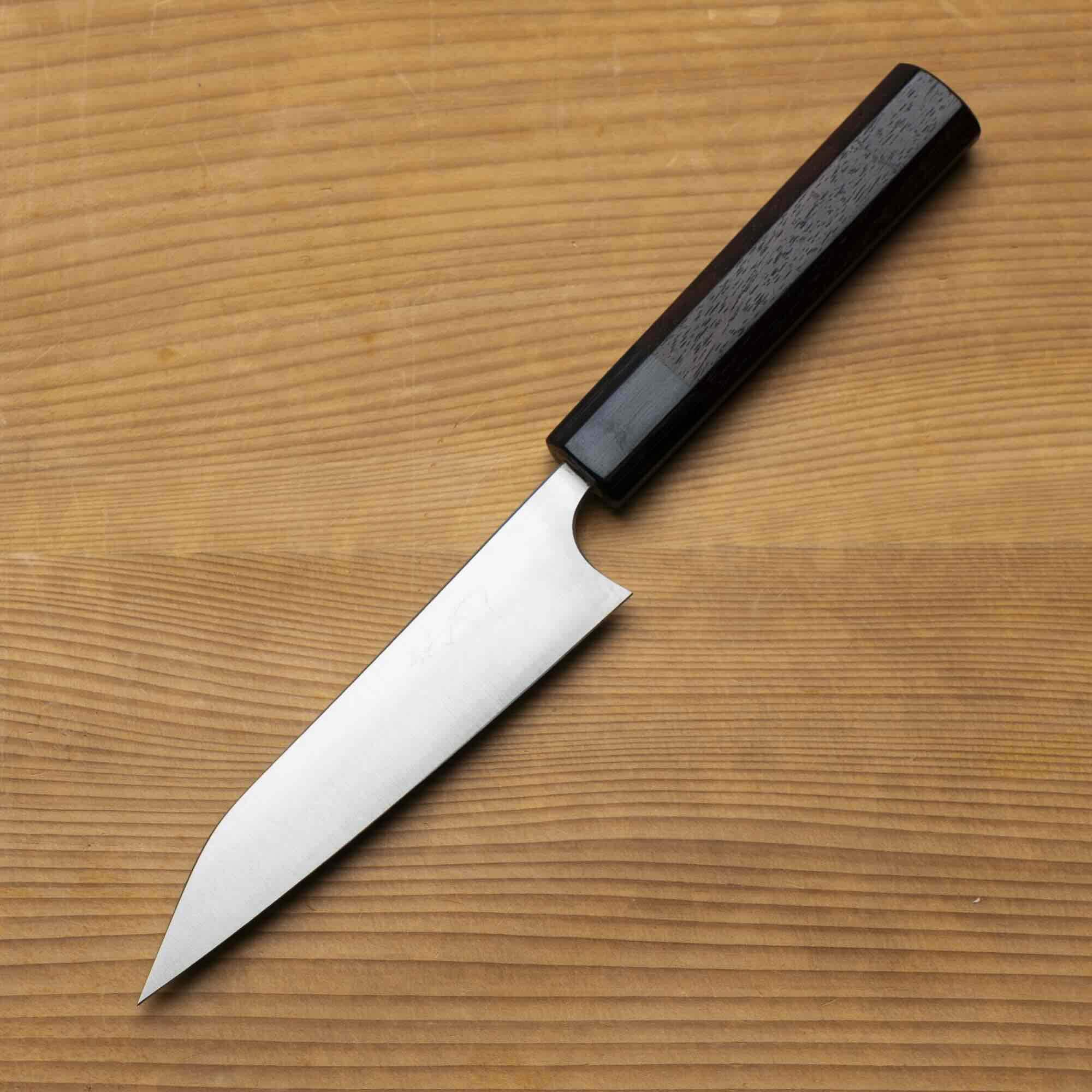 Knife with a black handle on a wooden surface